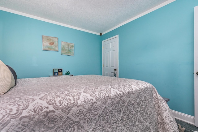 bedroom featuring ornamental molding, a textured ceiling, and baseboards