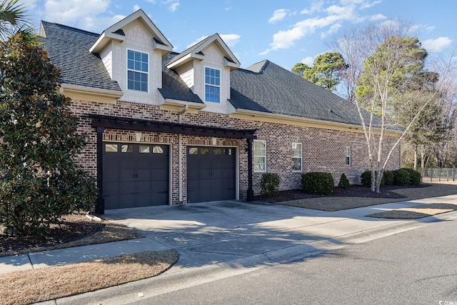 view of front of property featuring an attached garage, a shingled roof, concrete driveway, and brick siding