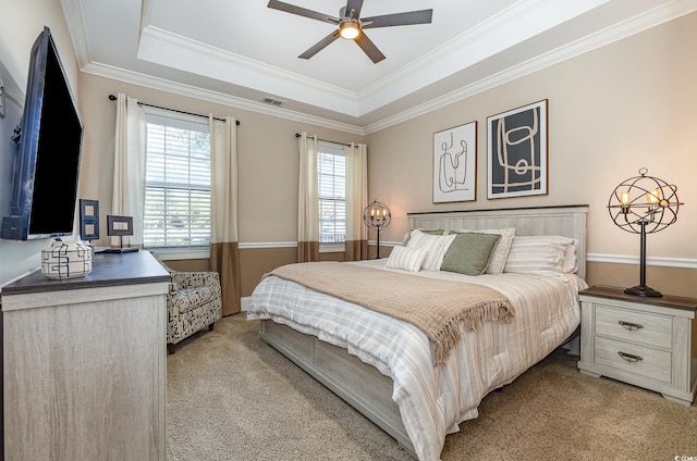 bedroom featuring light carpet, a tray ceiling, visible vents, and crown molding