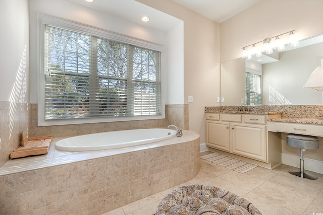 bathroom featuring a garden tub, vanity, and tile patterned floors