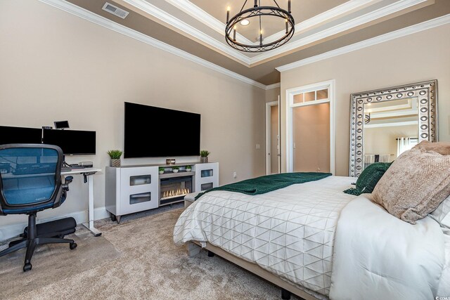 carpeted bedroom with visible vents, baseboards, an inviting chandelier, a tray ceiling, and crown molding