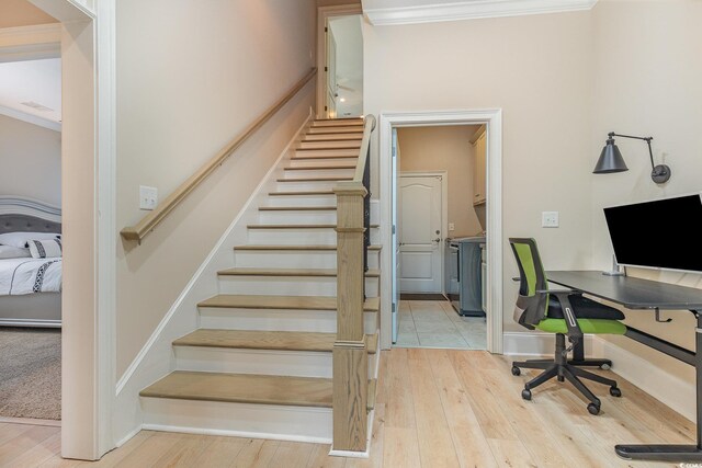 stairs with baseboards, ornamental molding, and wood finished floors