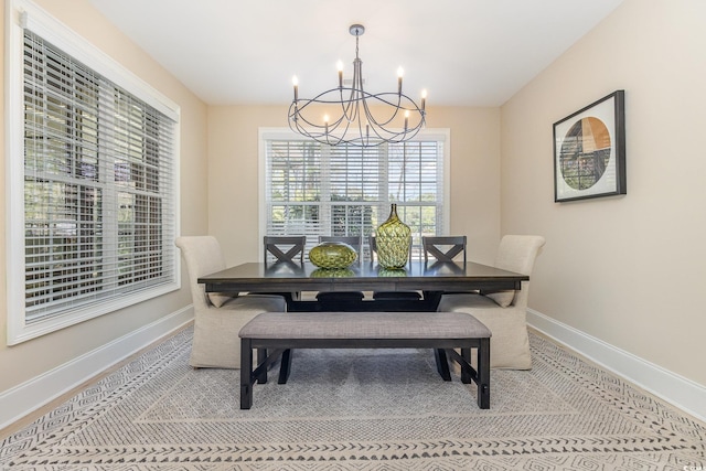 dining space featuring baseboards and an inviting chandelier