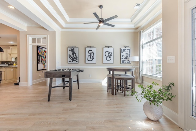 rec room featuring light wood-style flooring, a raised ceiling, and visible vents