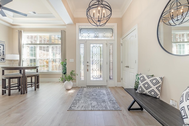 foyer entrance featuring an inviting chandelier, visible vents, ornamental molding, and wood finished floors