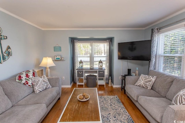 living room featuring a healthy amount of sunlight, baseboards, ornamental molding, and wood finished floors