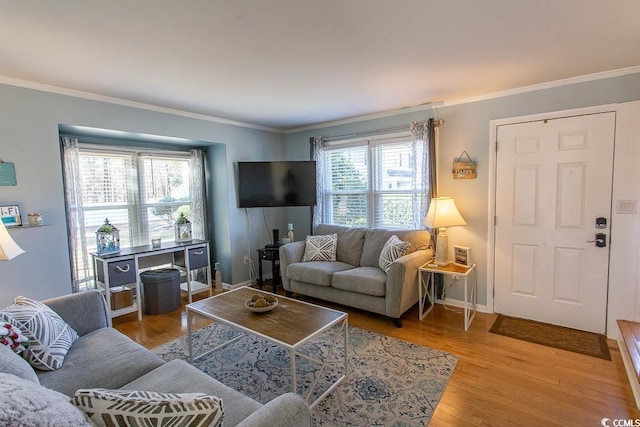 living area with ornamental molding, plenty of natural light, and wood finished floors