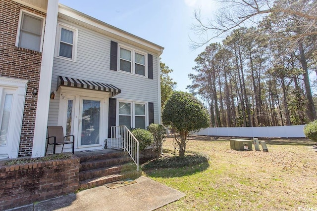 view of front of home with a front yard and fence