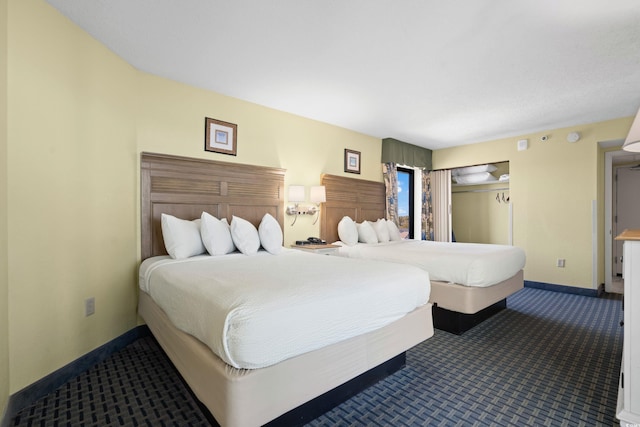 bedroom featuring dark colored carpet and baseboards