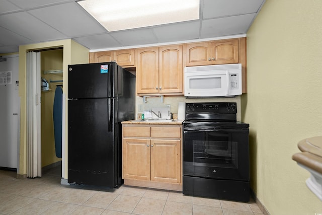 kitchen with light tile patterned floors, a drop ceiling, a sink, light countertops, and black appliances