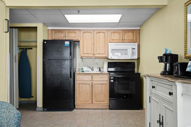 kitchen featuring black appliances, light tile patterned floors, light countertops, and a drop ceiling