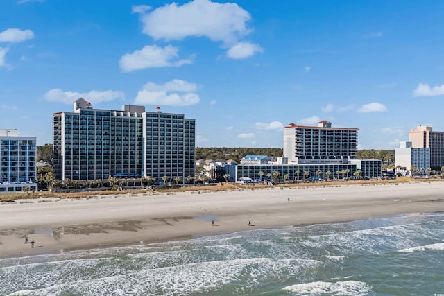 drone / aerial view featuring a view of city, a water view, and a view of the beach