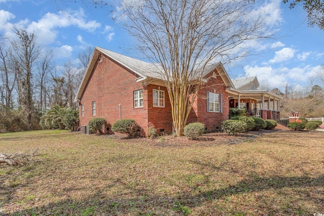 view of property exterior featuring crawl space, a yard, a porch, and brick siding