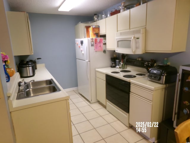 kitchen with white appliances, cream cabinets, light countertops, a sink, and light tile patterned flooring