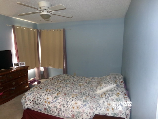 bedroom featuring carpet floors, ceiling fan, and a textured ceiling