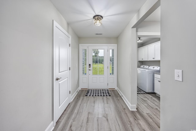 entryway with baseboards, separate washer and dryer, visible vents, and light wood-style floors