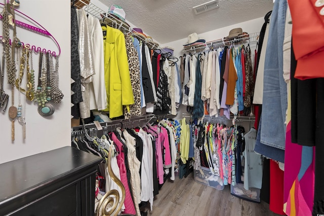 walk in closet with visible vents and wood finished floors