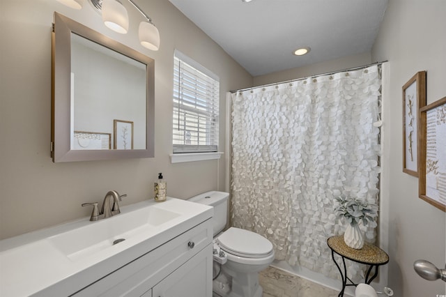 bathroom with curtained shower, toilet, and vanity