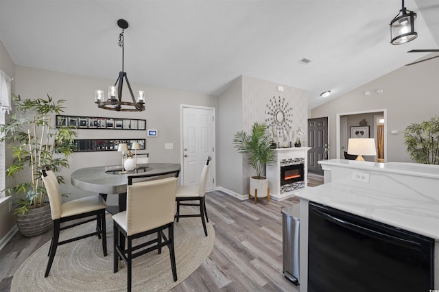 dining area with wood finished floors, visible vents, lofted ceiling, a fireplace, and wine cooler