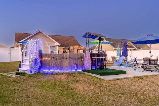 view of jungle gym featuring a patio, a lawn, and a fenced backyard