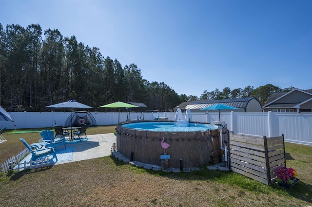 view of swimming pool featuring a lawn, a fenced in pool, and a fenced backyard