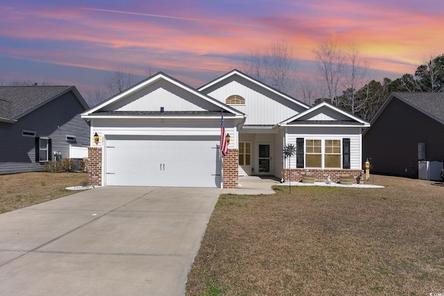 view of front of home featuring brick siding, a yard, and an attached garage