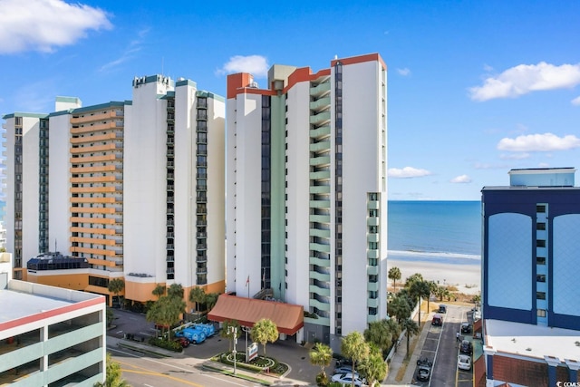 view of building exterior featuring a water view and a view of the beach