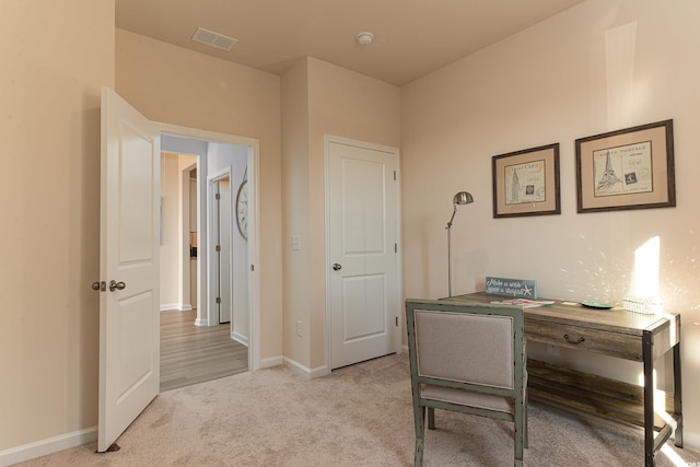 office featuring light colored carpet, baseboards, and visible vents