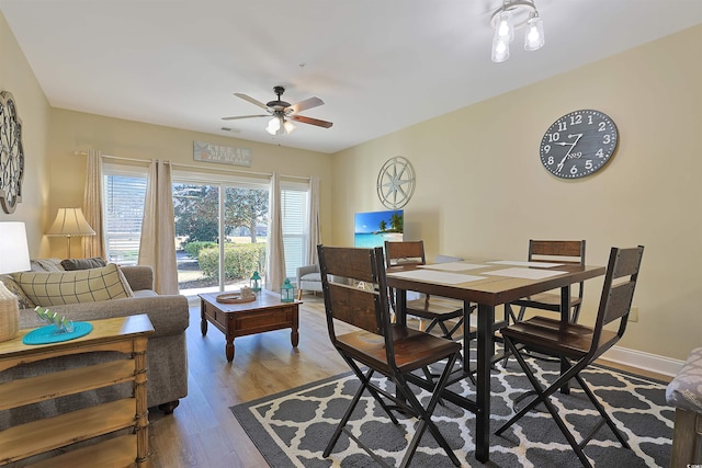 dining room with ceiling fan, light wood-type flooring, visible vents, and baseboards