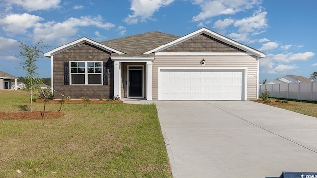 view of front facade with a garage, driveway, a front lawn, and fence