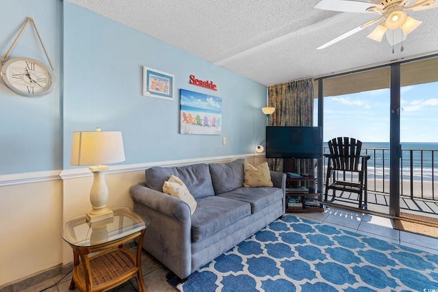 living room featuring a ceiling fan, floor to ceiling windows, and a textured ceiling