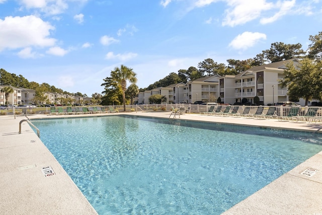 pool with a residential view, fence, and a patio