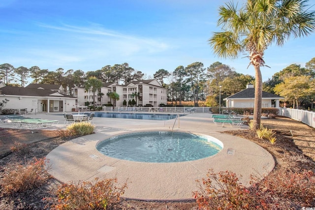 community pool with a patio and fence