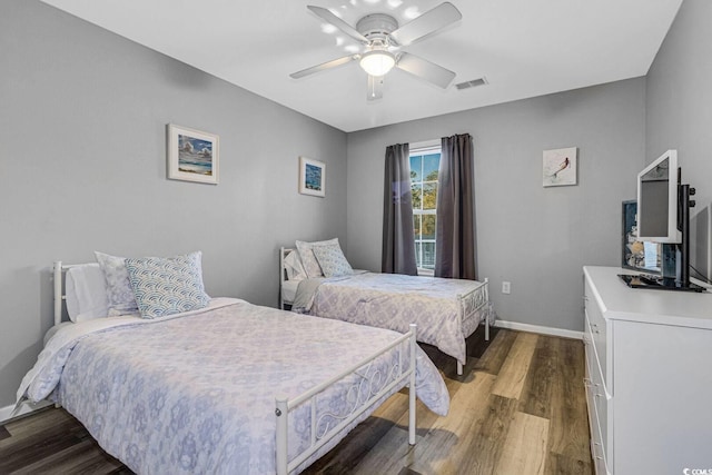 bedroom featuring a ceiling fan, dark wood finished floors, visible vents, and baseboards