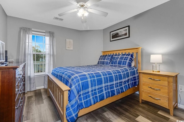 bedroom with baseboards, visible vents, and wood finished floors