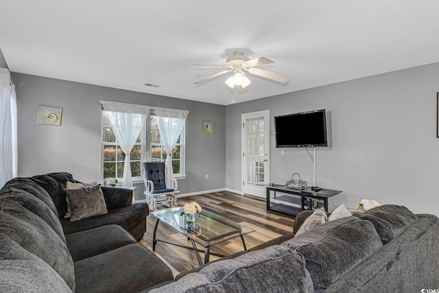 living room featuring a ceiling fan, baseboards, and wood finished floors