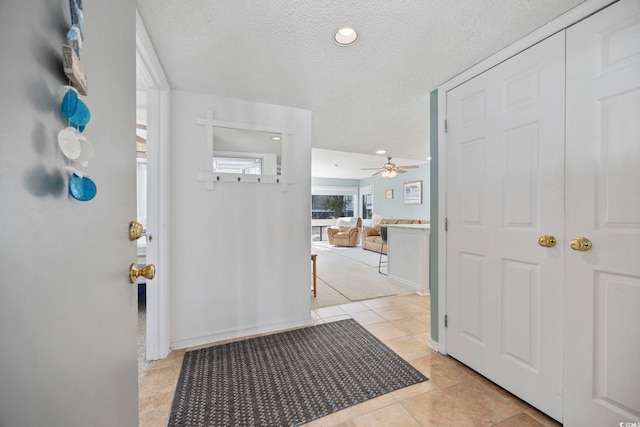 entryway featuring light tile patterned floors and a textured ceiling