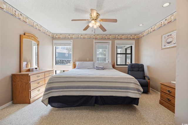 bedroom featuring light carpet, a ceiling fan, and a textured ceiling