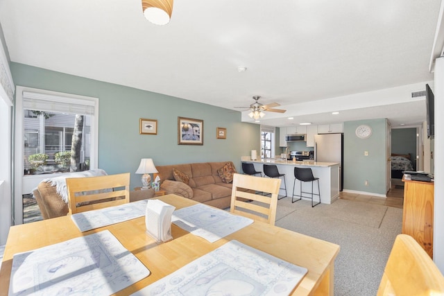 dining space featuring a ceiling fan, visible vents, and baseboards