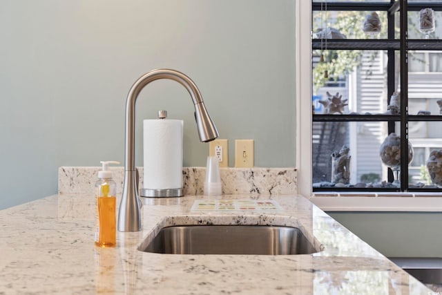 interior details with light stone counters and a sink