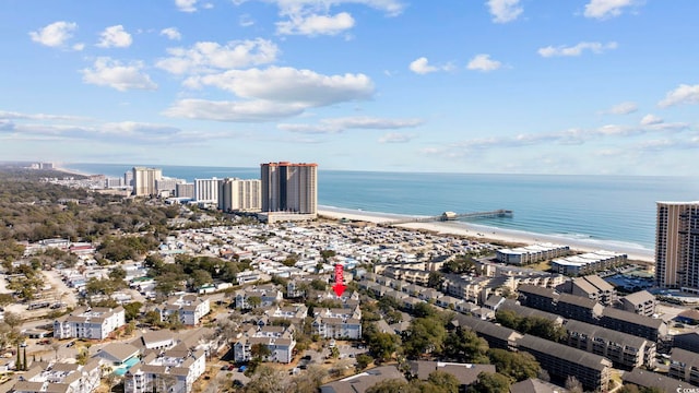 drone / aerial view featuring a view of city, a beach view, and a water view