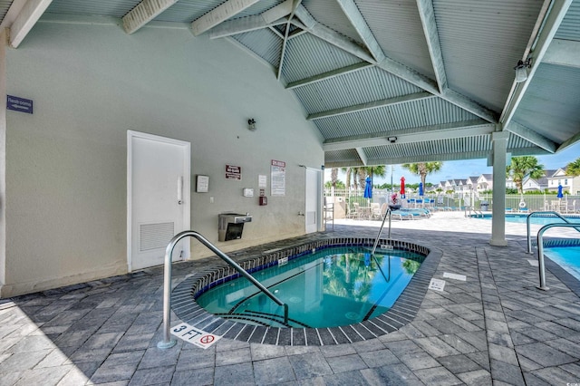 pool featuring a community hot tub and a patio