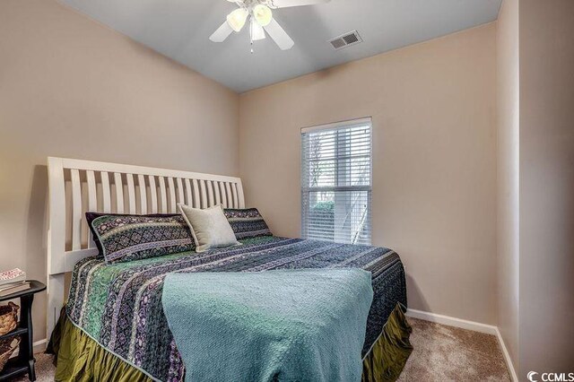 carpeted bedroom featuring visible vents, baseboards, and ceiling fan