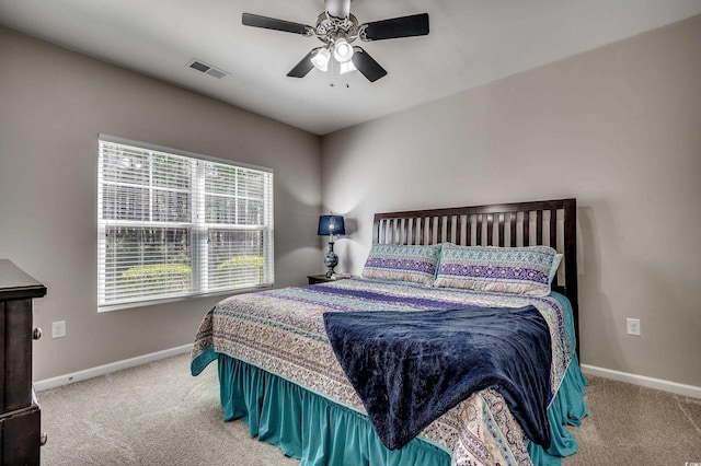 carpeted bedroom featuring a ceiling fan, visible vents, and baseboards