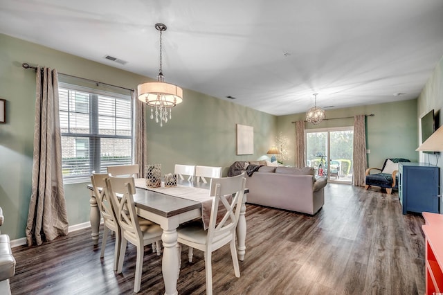 dining area with wood finished floors, visible vents, baseboards, and an inviting chandelier