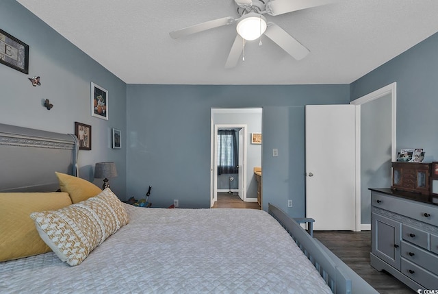 bedroom featuring dark wood-style floors, connected bathroom, a textured ceiling, and a ceiling fan