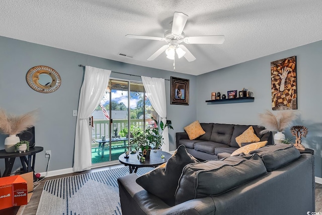 living room featuring baseboards, visible vents, ceiling fan, wood finished floors, and a textured ceiling