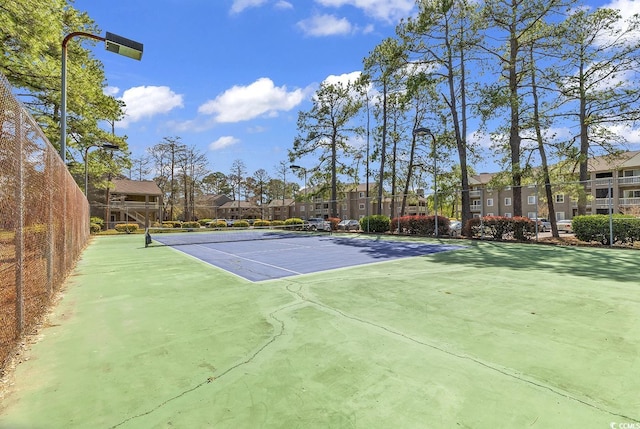 view of sport court with fence and a residential view