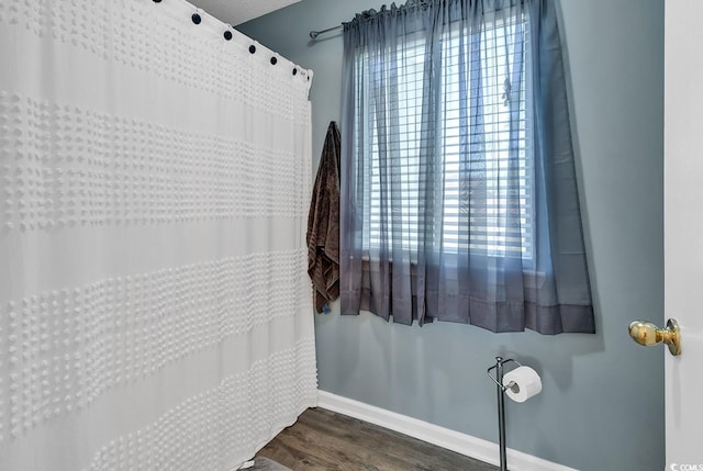 full bathroom with baseboards and wood finished floors