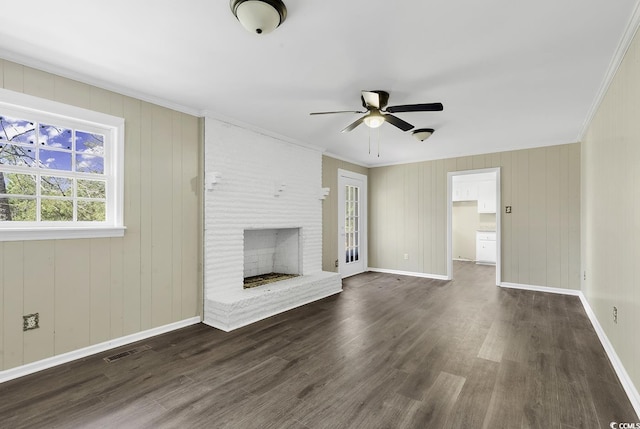 unfurnished living room featuring baseboards, visible vents, ornamental molding, dark wood-style flooring, and a brick fireplace